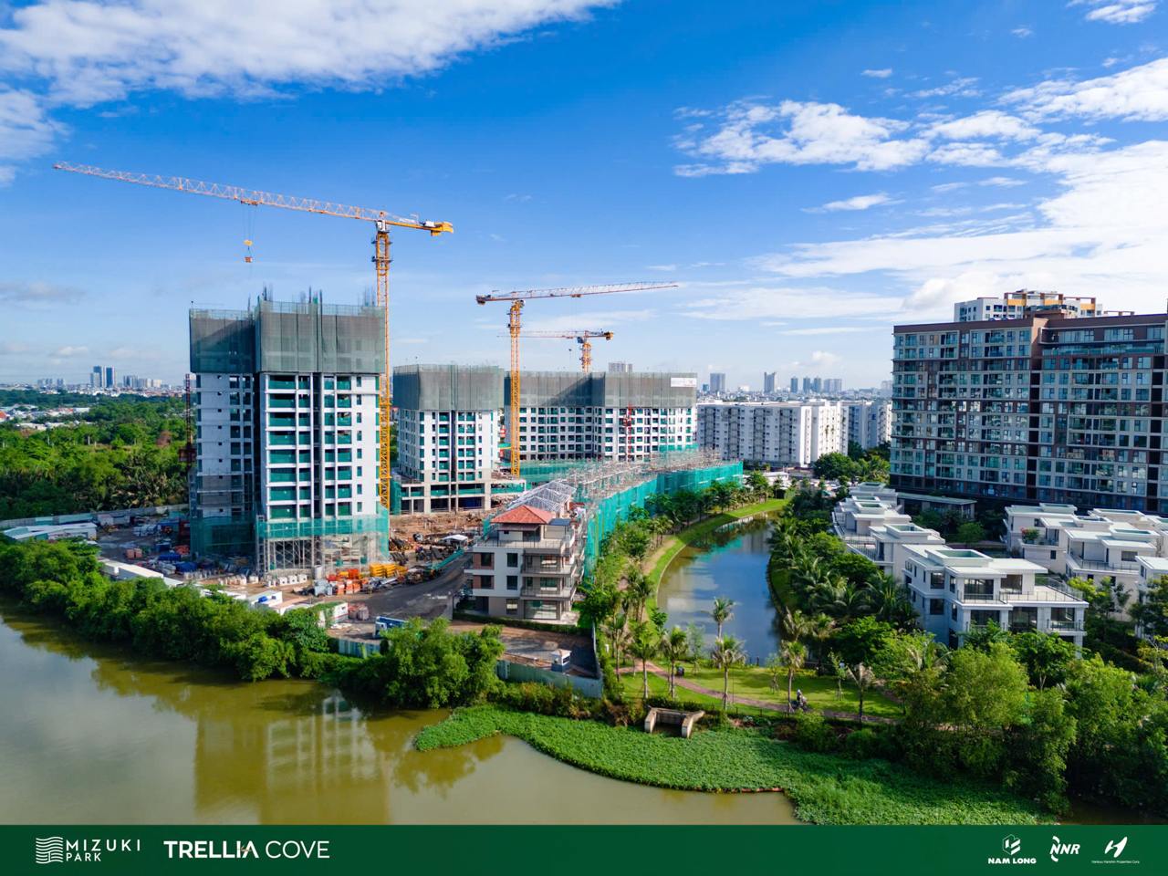 Toàn cảnh công trường tháp Trellia Cove Mizuki Park bên kênh đào, cần cẩu tháp đang thi công phần thân tháng 7/2026